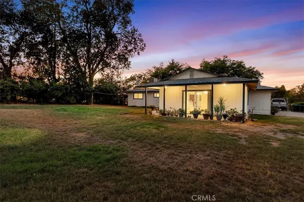 a view of a house with backyard and a tree
