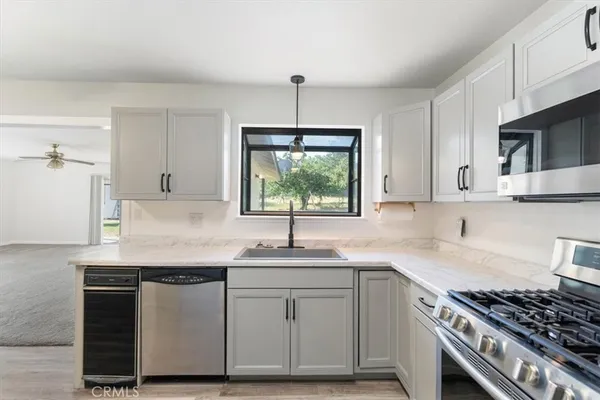 a kitchen with stainless steel appliances granite countertop a sink stove and cabinets