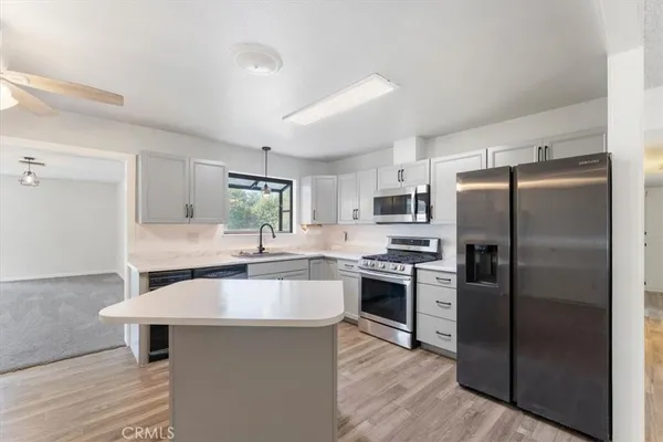 a kitchen with stainless steel appliances a sink stove refrigerator and cabinets