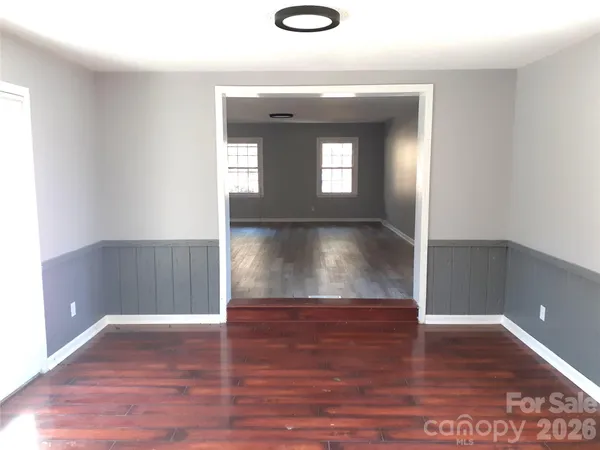 a view of a hallway with wooden floor and a window