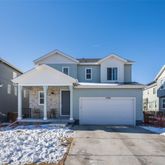 a front view of a house with a yard and large tree
