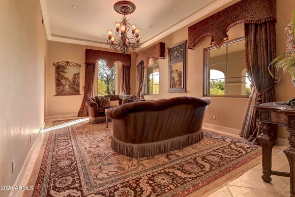 a bedroom with a bed a chandelier and dresser