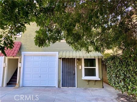a front view of a house with a tree