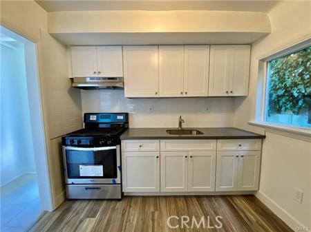314 Coronado Avenue, Unit C Long Beach, CA 90814 - Photo 5 of 19 a kitchen with stainless steel appliances granite countertop a stove and a white cabinets