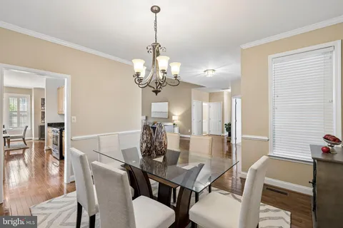 a view of a dining room with furniture a chandelier and wooden floor