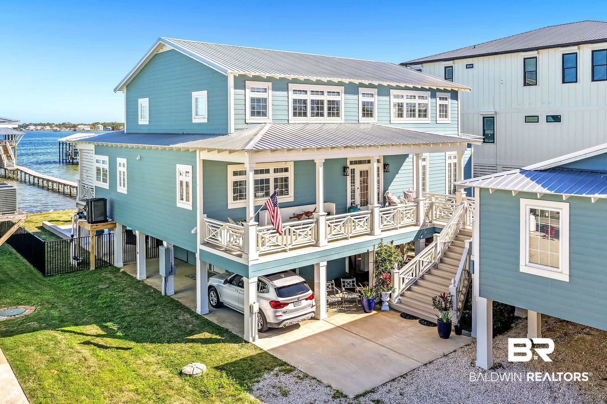 6434 County Road 95 Elberta, AL 36530 - Photo 59 of 99 Rear view of property featuring a carport, a metal roof, a yard, and a deck with water view