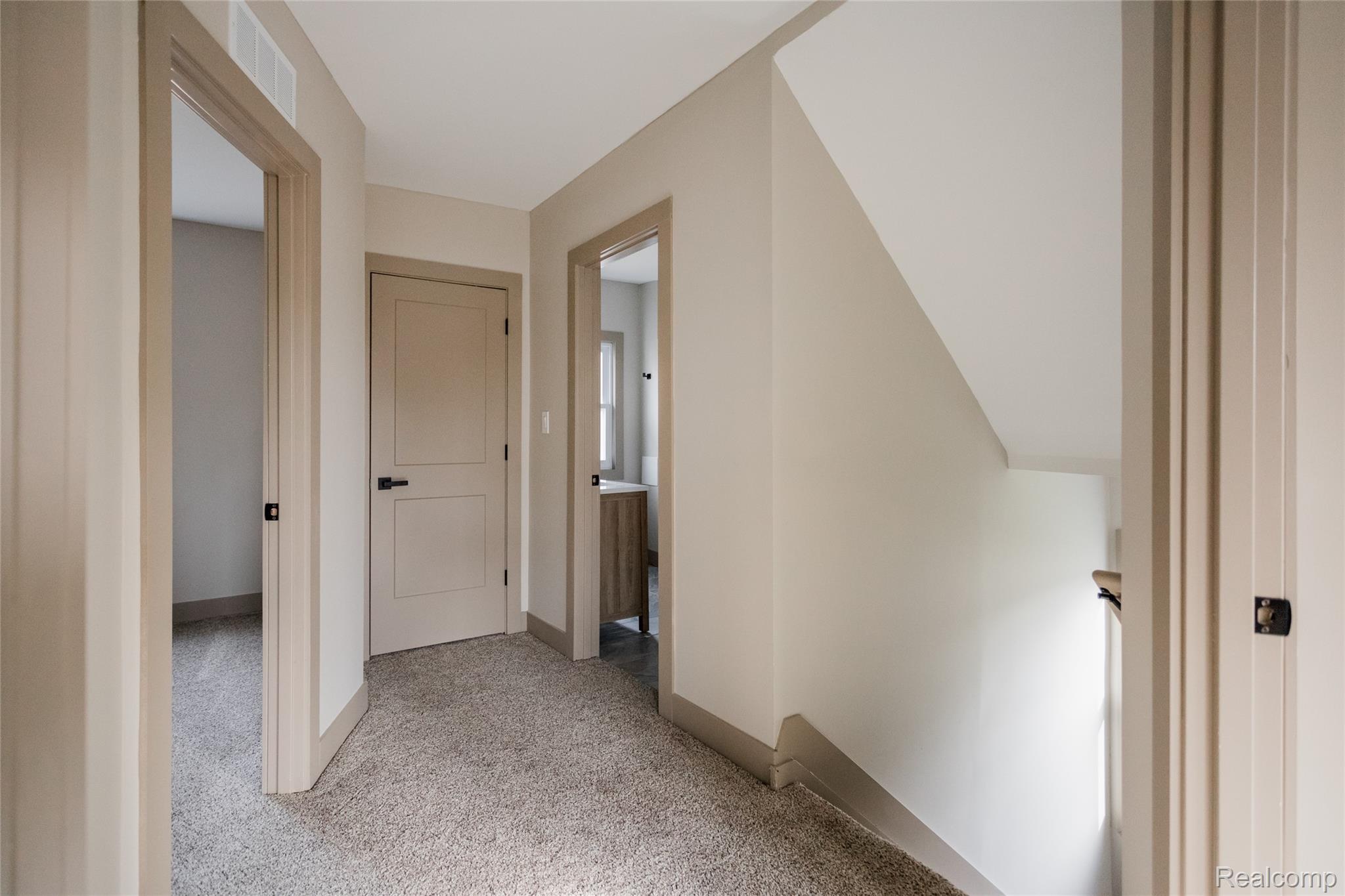 2630 Harding Street Detroit, MI 48214 - Photo 18 of 30 Carpeted hallway featuring warm neutral wall tones and coordinating trim