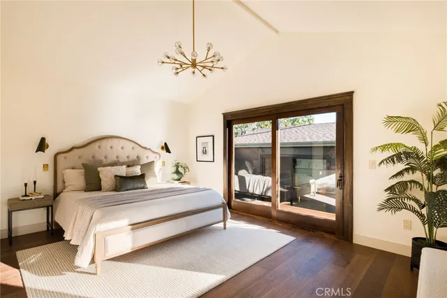 a bedroom with a large bed and a chandelier