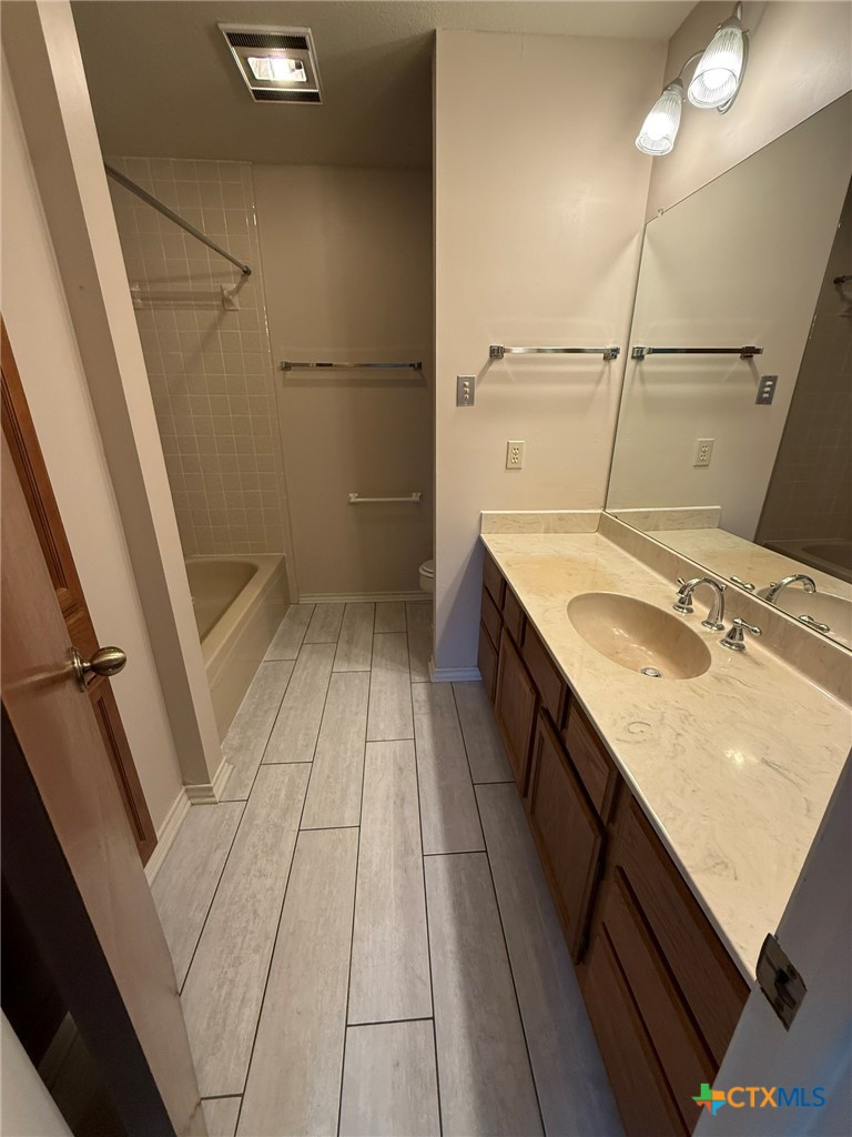 1133 Ashby Street, Unit C9 Seguin, TX 78155 - Photo 15 of 18 a bathroom with a granite countertop sink a toilet and shower