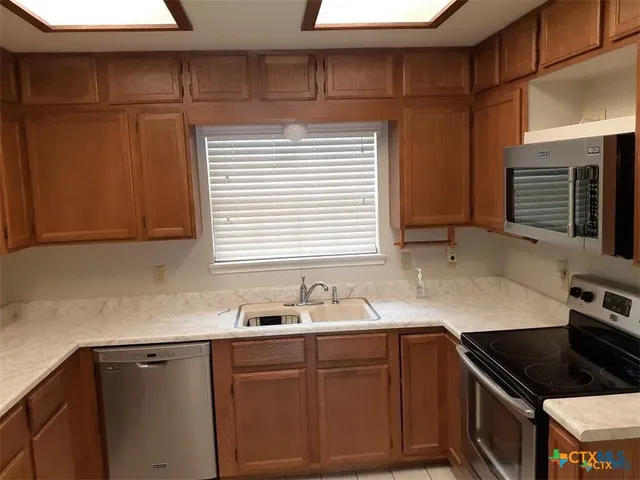 a kitchen with granite countertop cabinets sink and window