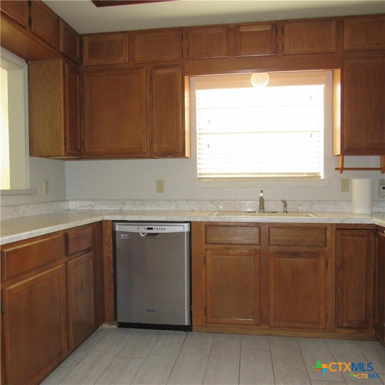 1133 Ashby Street, Unit C9 Seguin, TX 78155 - Photo 10 of 18 a kitchen with granite countertop cabinets sink and window