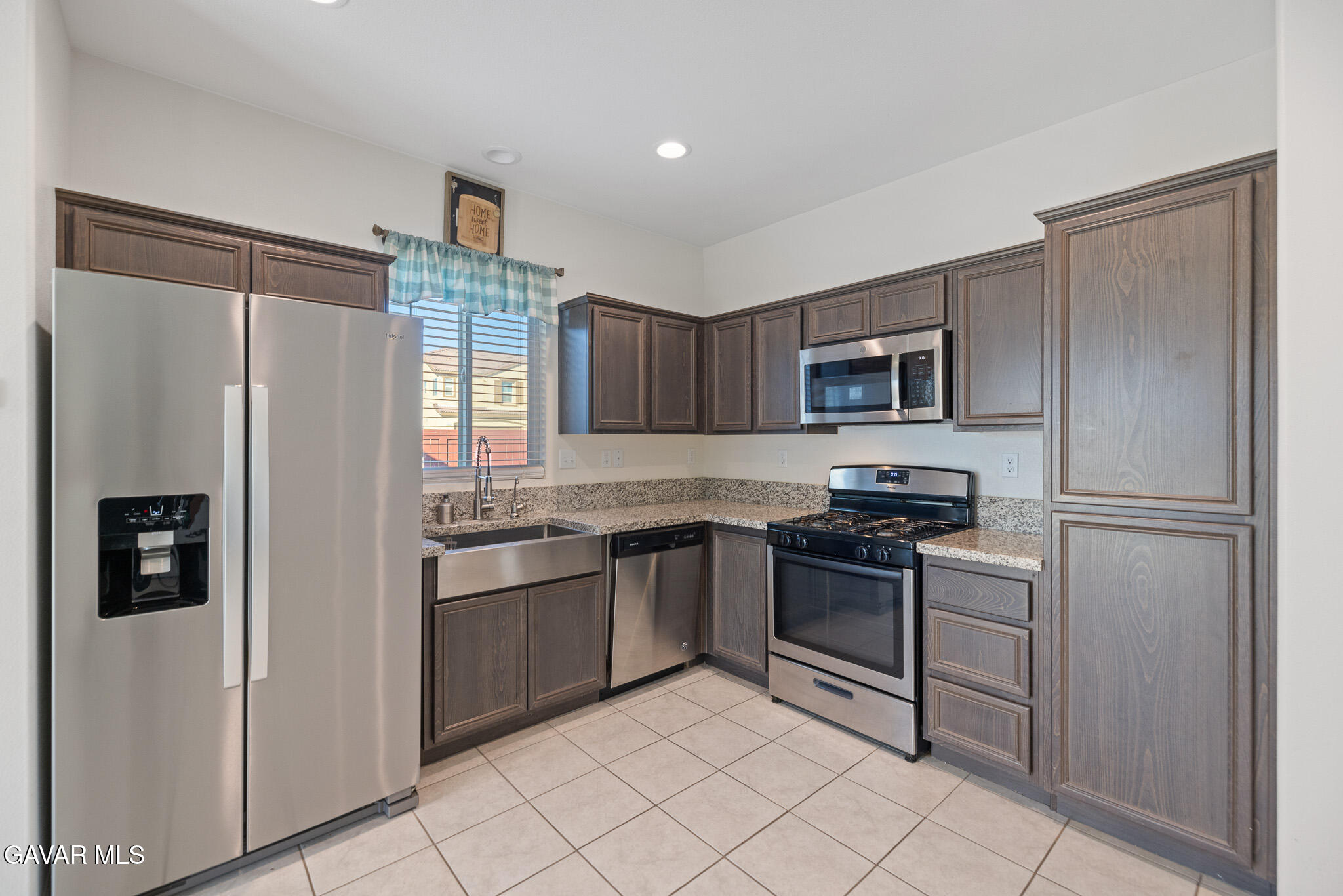 3124 Via Bella Rosa Avenue Rosamond, CA 93560 - Photo 10 of 36 a kitchen with stainless steel appliances granite countertop a refrigerator sink and stove