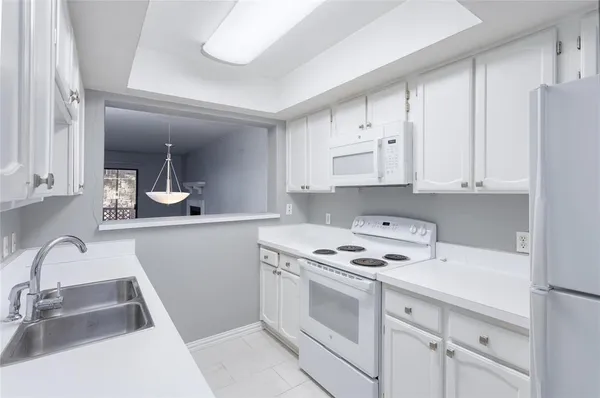 a kitchen with granite countertop a sink stove and cabinets
