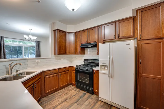 a kitchen with stainless steel appliances granite countertop a refrigerator sink and cabinets