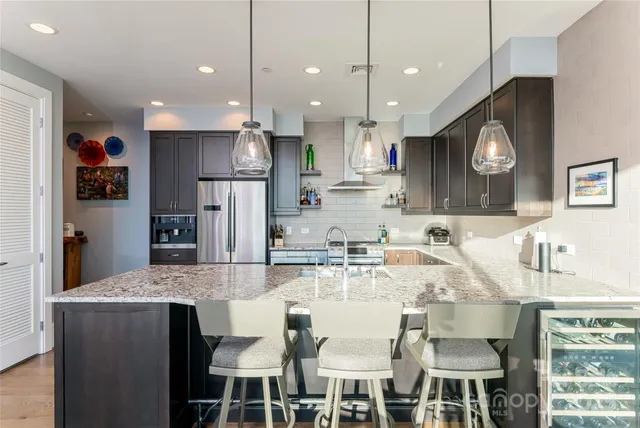 a kitchen with stainless steel appliances granite countertop a refrigerator stove and sink