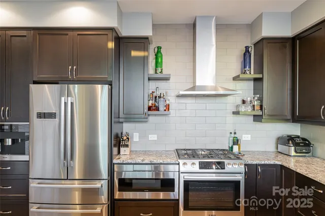 a view of kitchen with granite countertop cabinets and refrigerator
