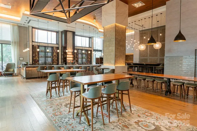 a living room with furniture a chandelier and large windows