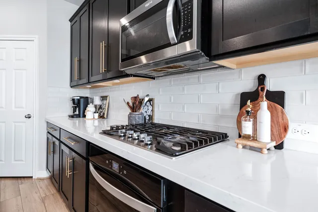 a kitchen with stainless steel appliances a stove a sink and cabinets