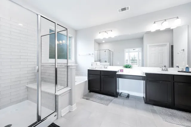 a bathroom with a double vanity sink mirror and shower