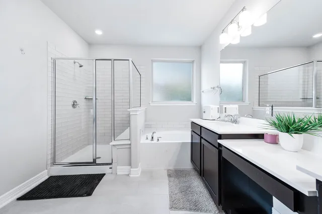 a bathroom with a double vanity sink toilet and shower