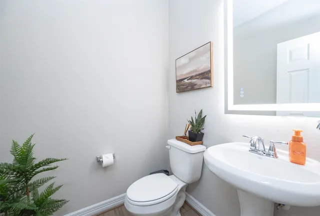 a bathroom with a sink mirror and toilet