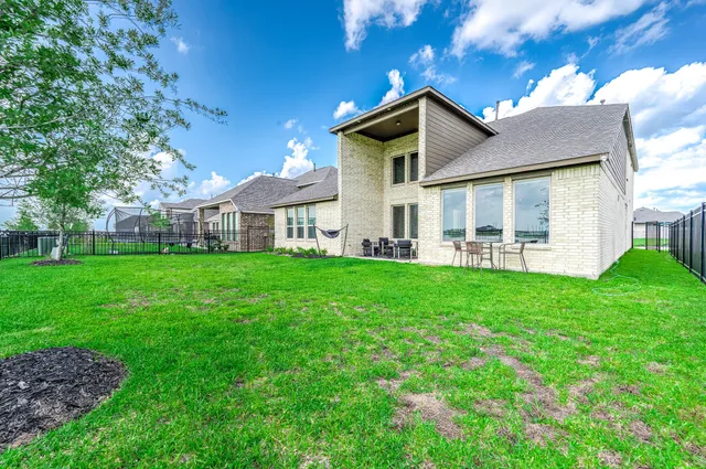 a view of an house with backyard space and balcony