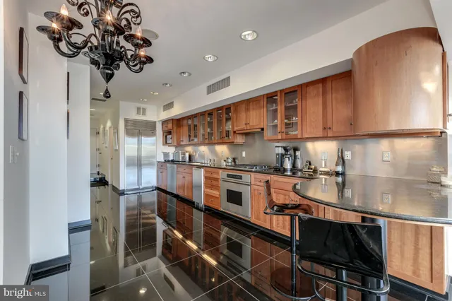 a kitchen with stainless steel appliances granite countertop a stove refrigerator sink and cabinets