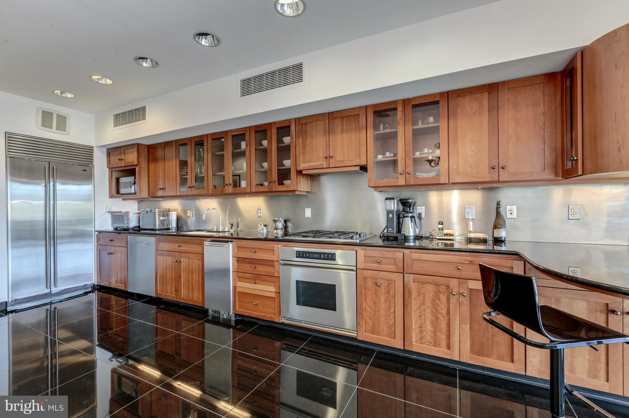 3620 Prospect Street Northwest Washington, DC 20007 - Photo 13 of 23 a kitchen with kitchen island granite countertop wooden cabinets and a stove