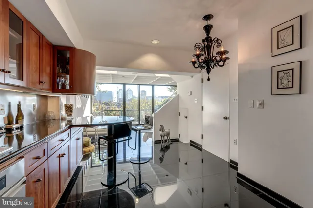 a kitchen with stainless steel appliances a sink a stove a refrigerator cabinets and a window