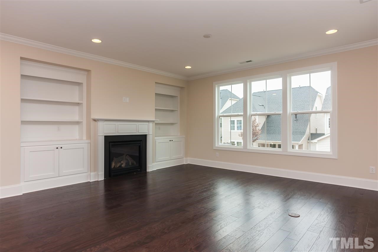 3908 Ivory Rose Lane Raleigh, NC 27612 - Photo 1 of 4 an empty room with wooden floor fireplace and windows