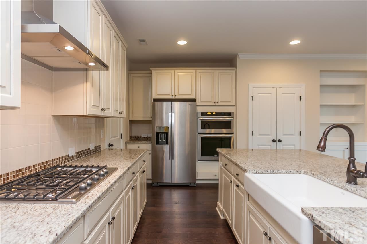 3908 Ivory Rose Lane Raleigh, NC 27612 - Photo 4 of 4 a kitchen with stainless steel appliances granite countertop a sink stove and refrigerator