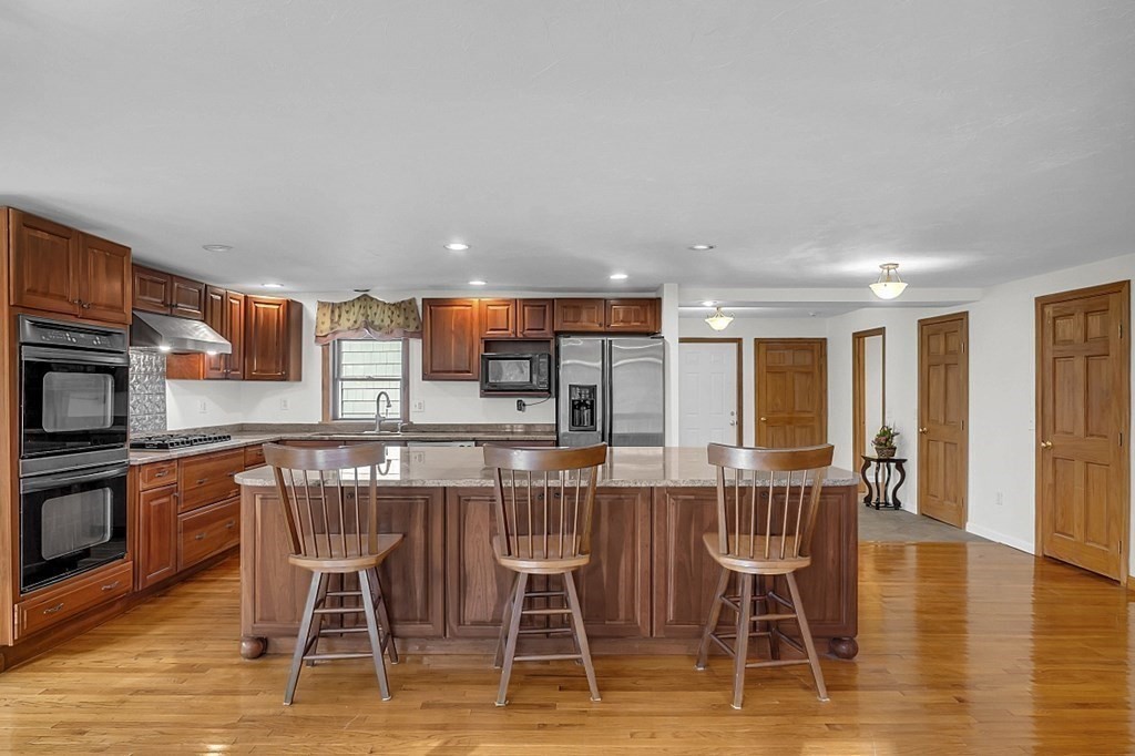 15 Stagecoach Road Topsfield, MA 01983 - Photo 9 of 40 a dining area with stainless steel appliances a dining table chairs and granite counter tops