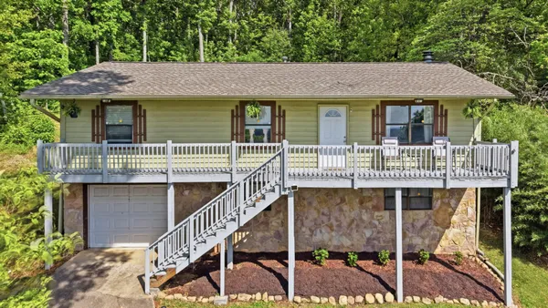a front view of house with deck and outdoor seating