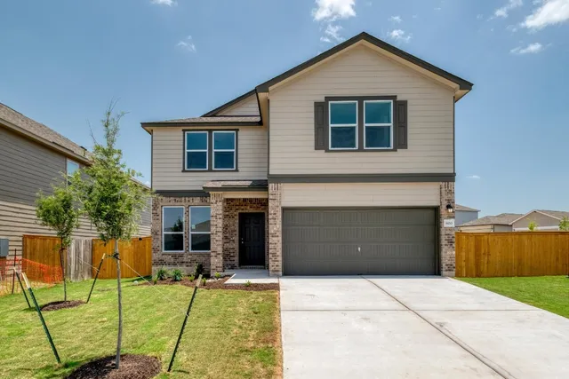 a front view of a house with a yard and garage
