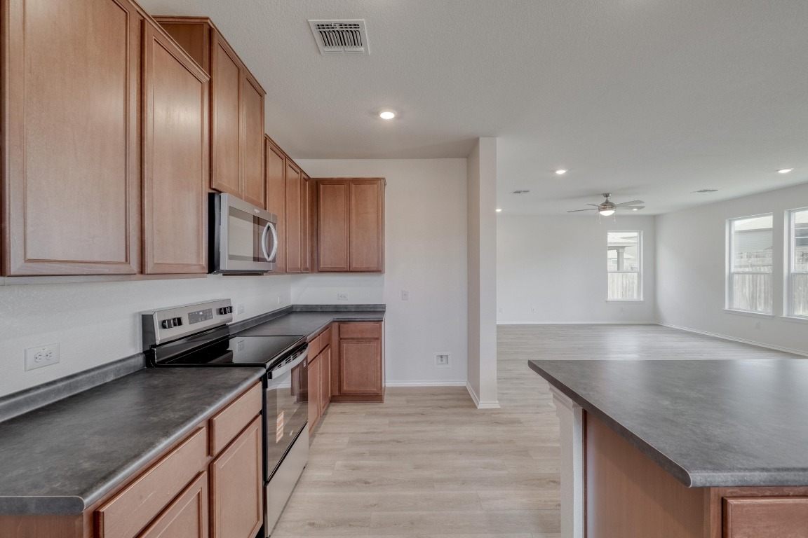 800 Yellow Ribbon Trail Jarrell, TX 76537 - Photo 11 of 32 a kitchen with stainless steel appliances granite countertop a sink a stove and a wooden cabinets