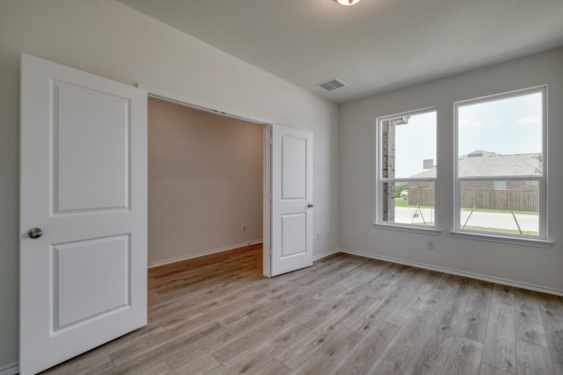 800 Yellow Ribbon Trail Jarrell, TX 76537 - Photo 12 of 32 an empty room with wooden floor and windows