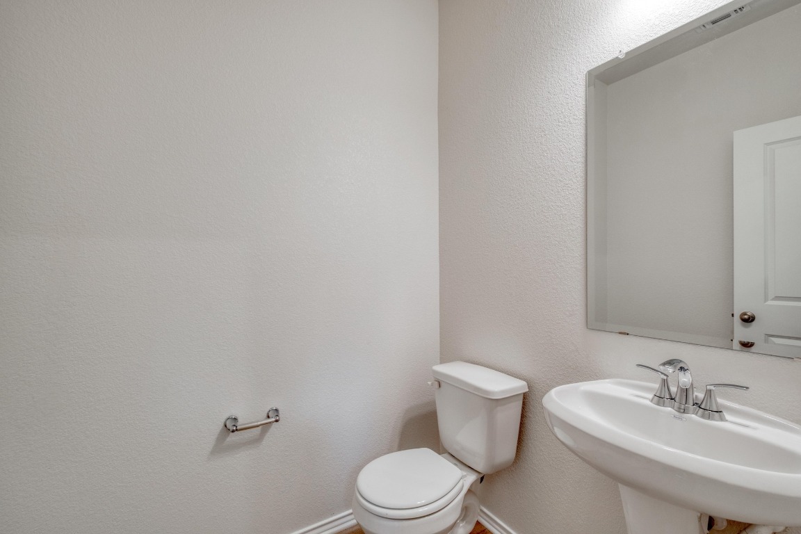 800 Yellow Ribbon Trail Jarrell, TX 76537 - Photo 14 of 32 a bathroom with a sink a toilet and mirror