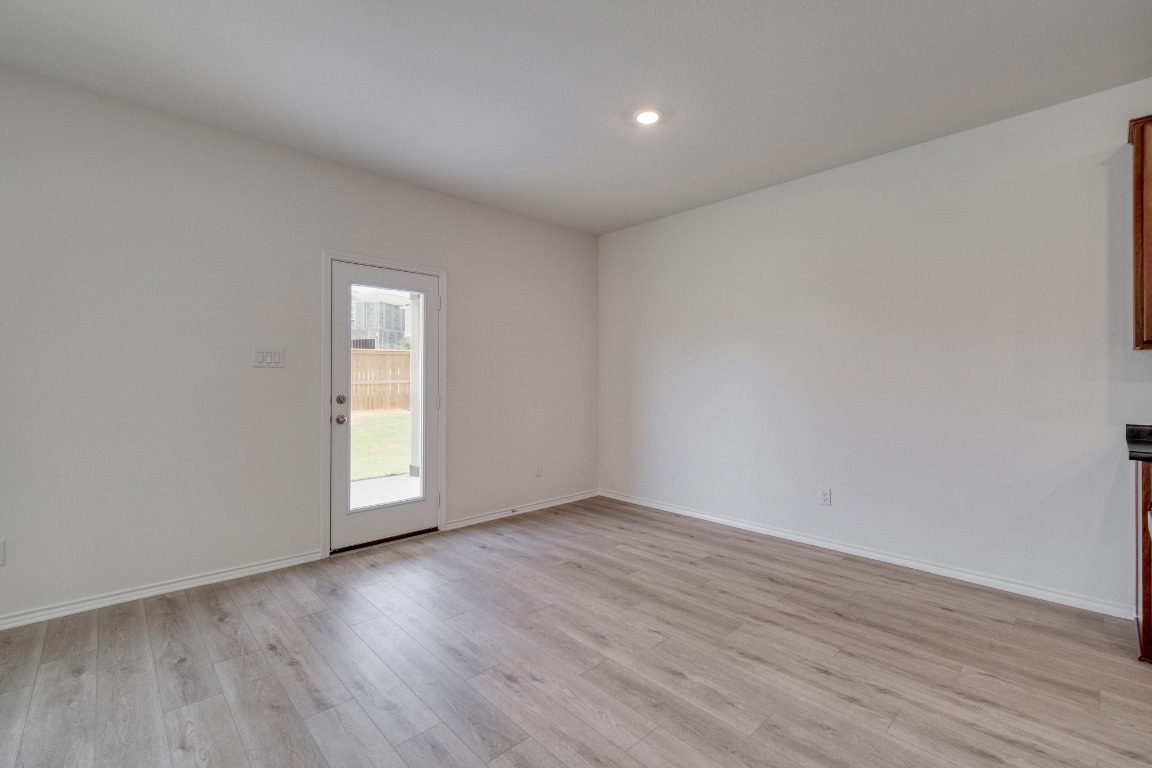 800 Yellow Ribbon Trail Jarrell, TX 76537 - Photo 7 of 32 an empty room with wooden floor and windows