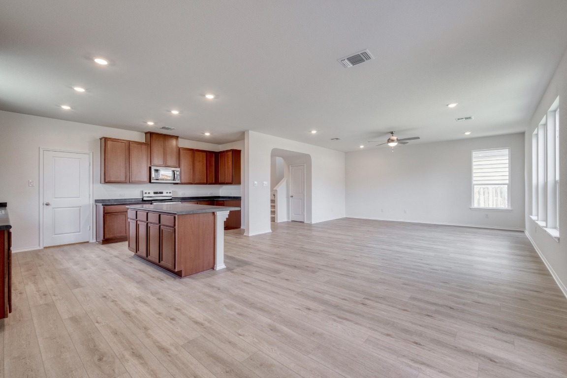 800 Yellow Ribbon Trail Jarrell, TX 76537 - Photo 8 of 32 a large kitchen with stainless steel appliances granite countertop a large counter top a stove and a wooden floors