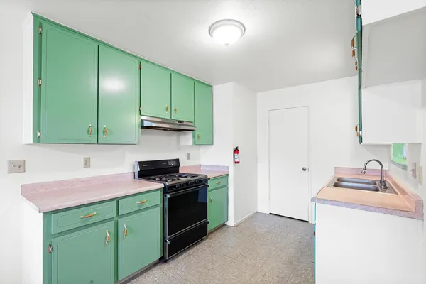 a kitchen with cabinets a sink and a stove
