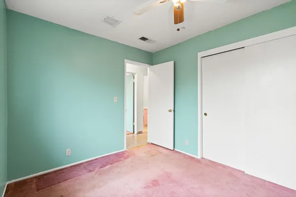 a view of empty room with a ceiling fan and a window