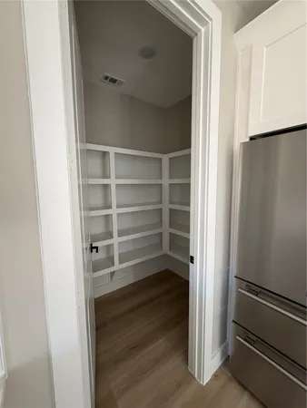 a view of walk in closet with empty racks