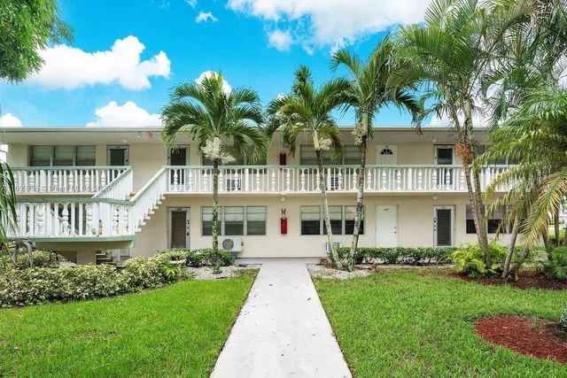 a front view of a house with a garden and plants