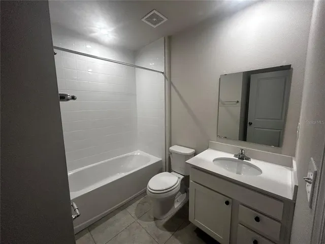 a bathroom with a granite countertop sink a toilet and shower