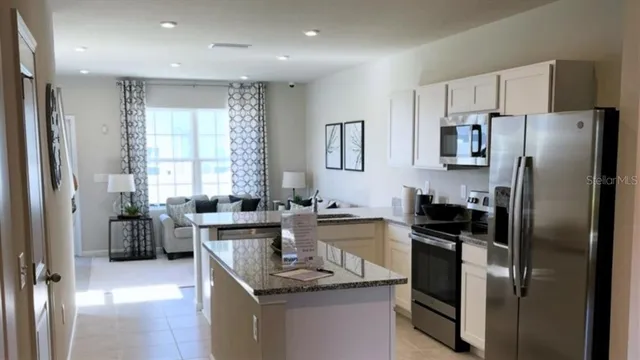 a kitchen with stainless steel appliances granite countertop a stove a microwave and a sink