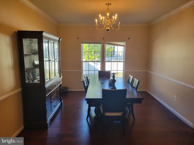 a view of a dining room with furniture a chandelier and wooden floor