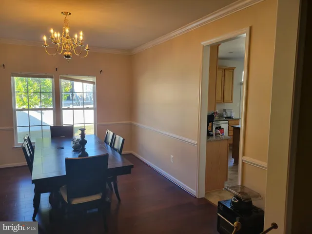 a view of a dining room with furniture a chandelier and window