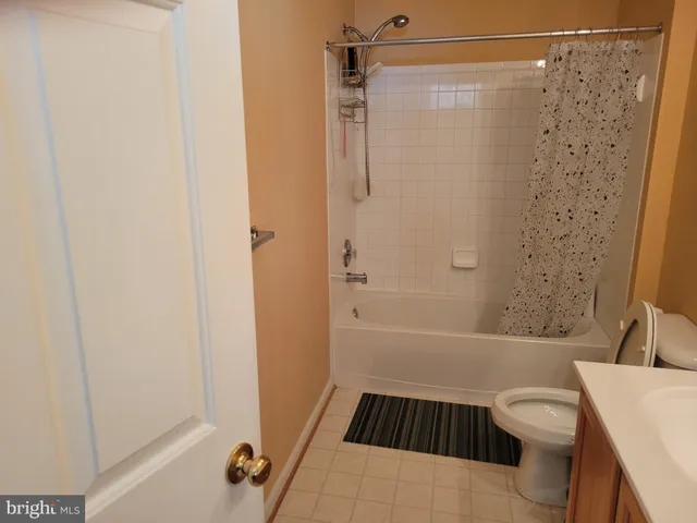 a bathroom with a sink a toilet a shower curtain and a bath tub