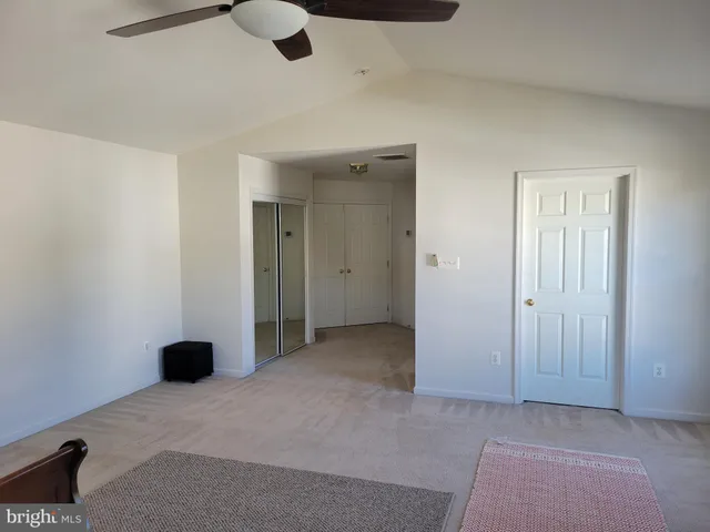 an empty room with closet and windows