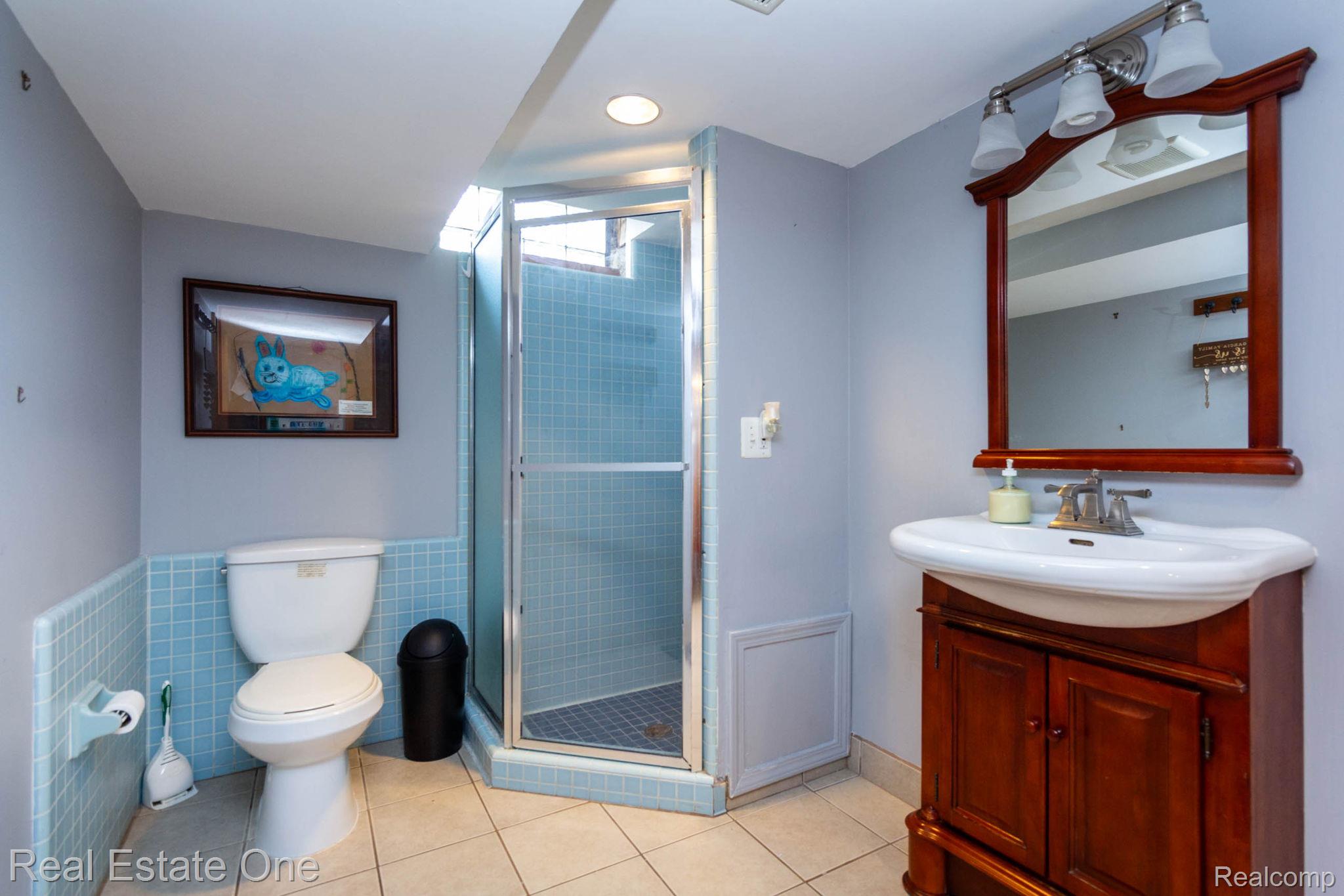 220 Winry Drive Rochester, MI 48307 - Photo 23 of 35 Bathroom featuring a stand-up shower with glass enclosure, white toilet, and a wood vanity with an integrated sink